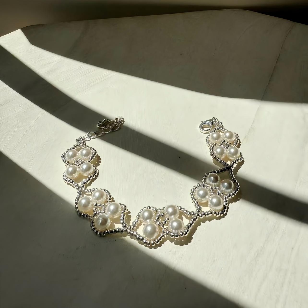 Pearl bracelet on a textured surface with soft shadows