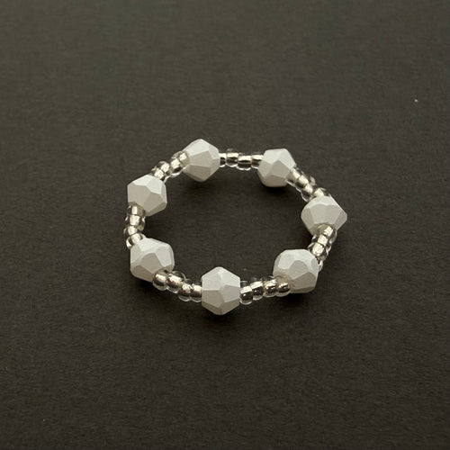 Beaded ring with faceted beads on a dark background