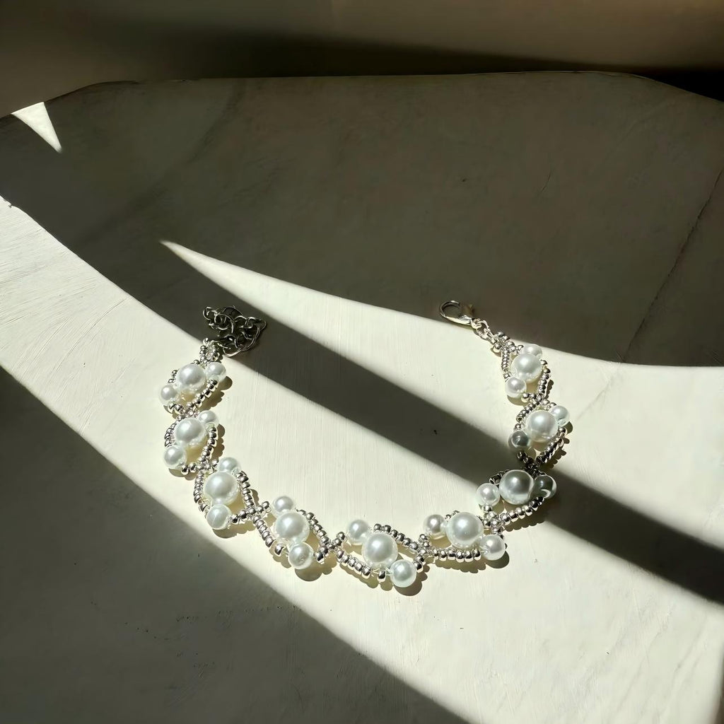 Pearl Bracelet on a textured surface with sunlight casting shadows