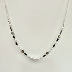 Necklace with pearls and black beads on a light gray background