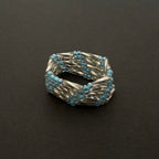 Silver and blue beaded ring on a dark background