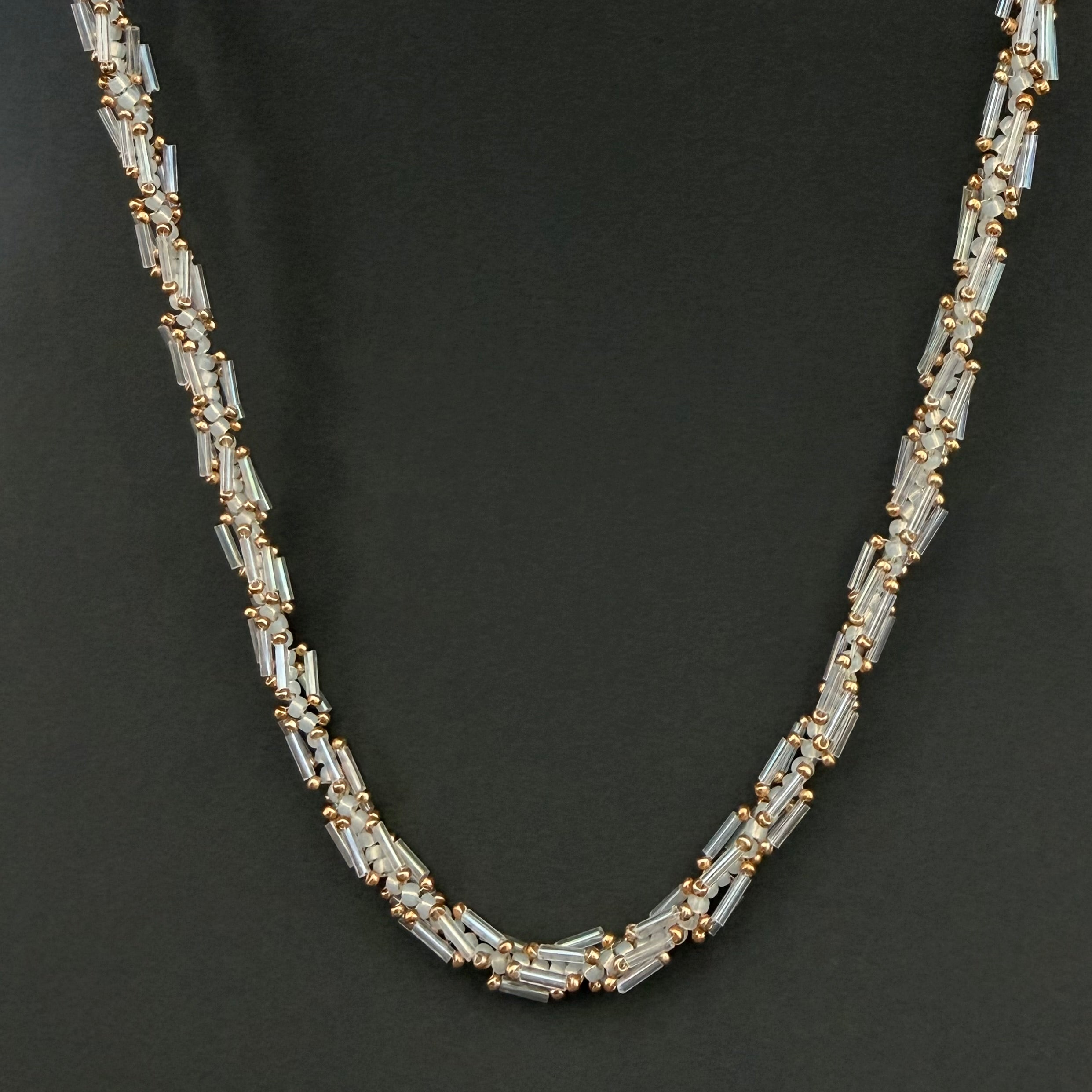 Necklace with clear and gold beads on a black background